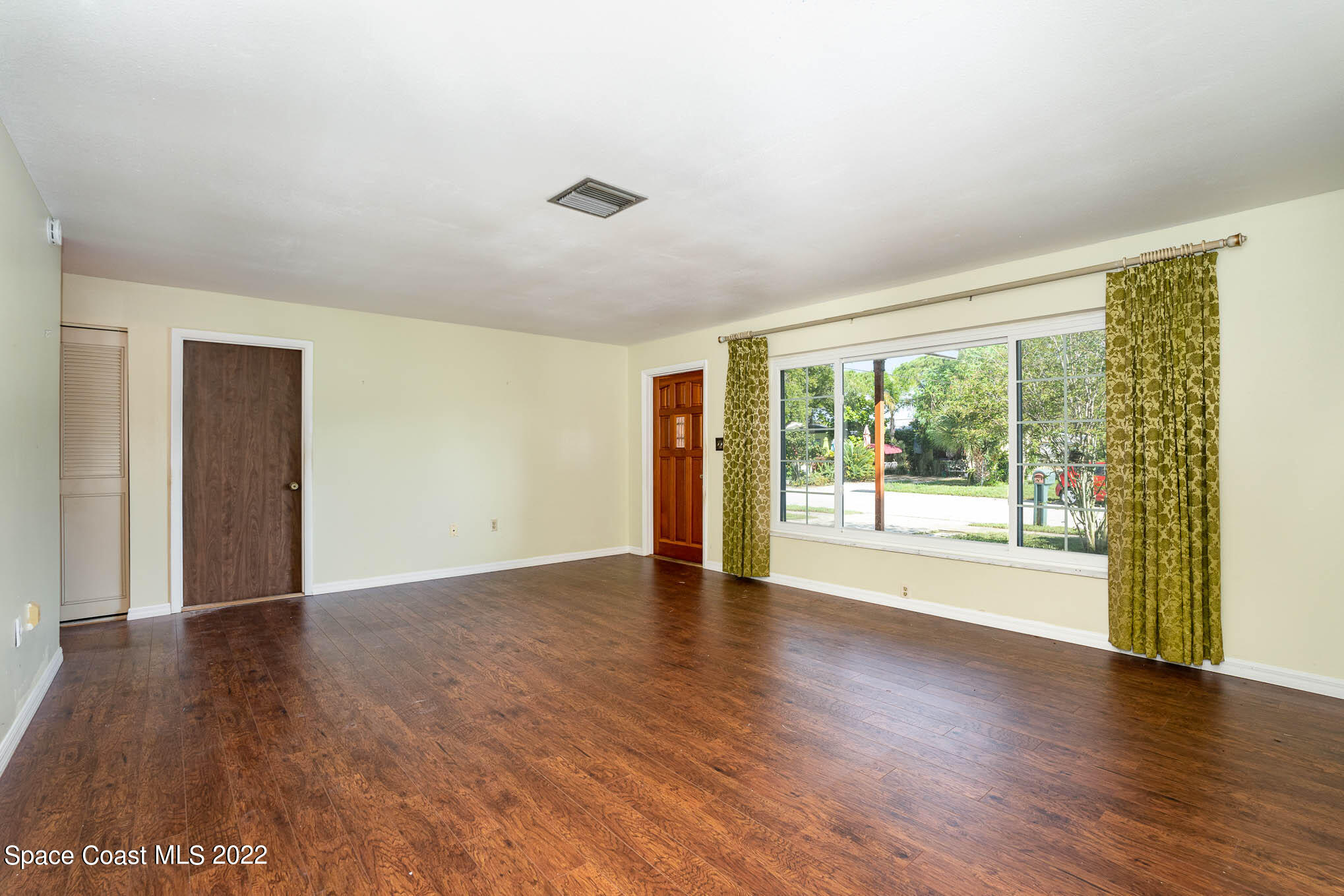 447 Count Street Melbourne, FL 32901 - Photo 5 of 24 a view of an empty room with wooden floor and a window