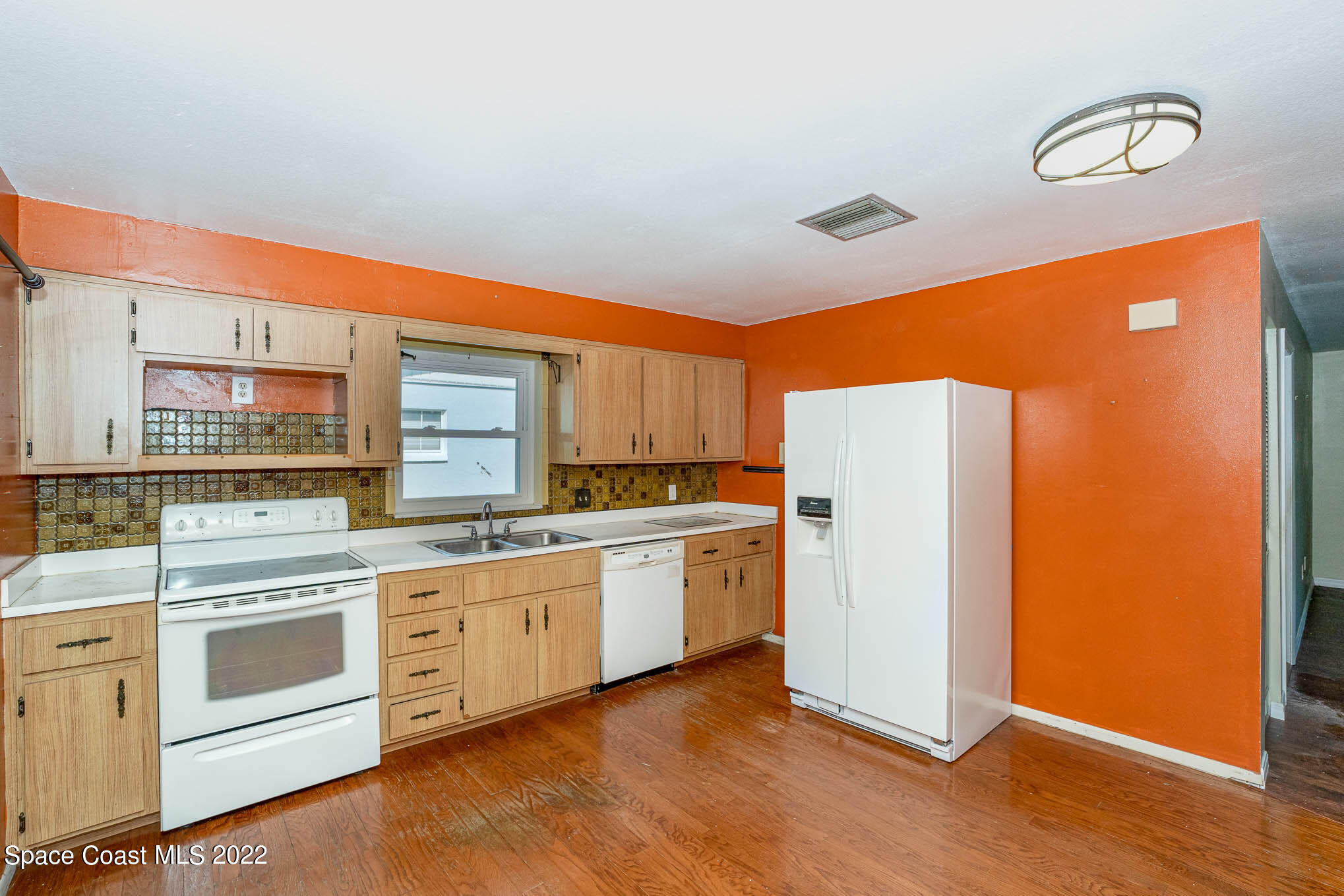 447 Count Street Melbourne, FL 32901 - Photo 7 of 24 a kitchen with white cabinets and white appliances