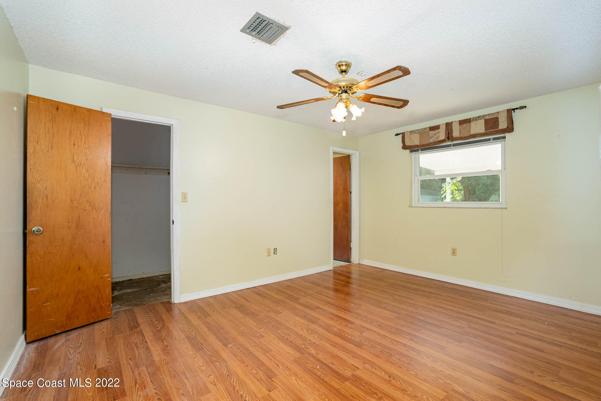 447 Count Street Melbourne, FL 32901 - Photo 9 of 24 a view of an empty room with wooden floor and a ceiling fan