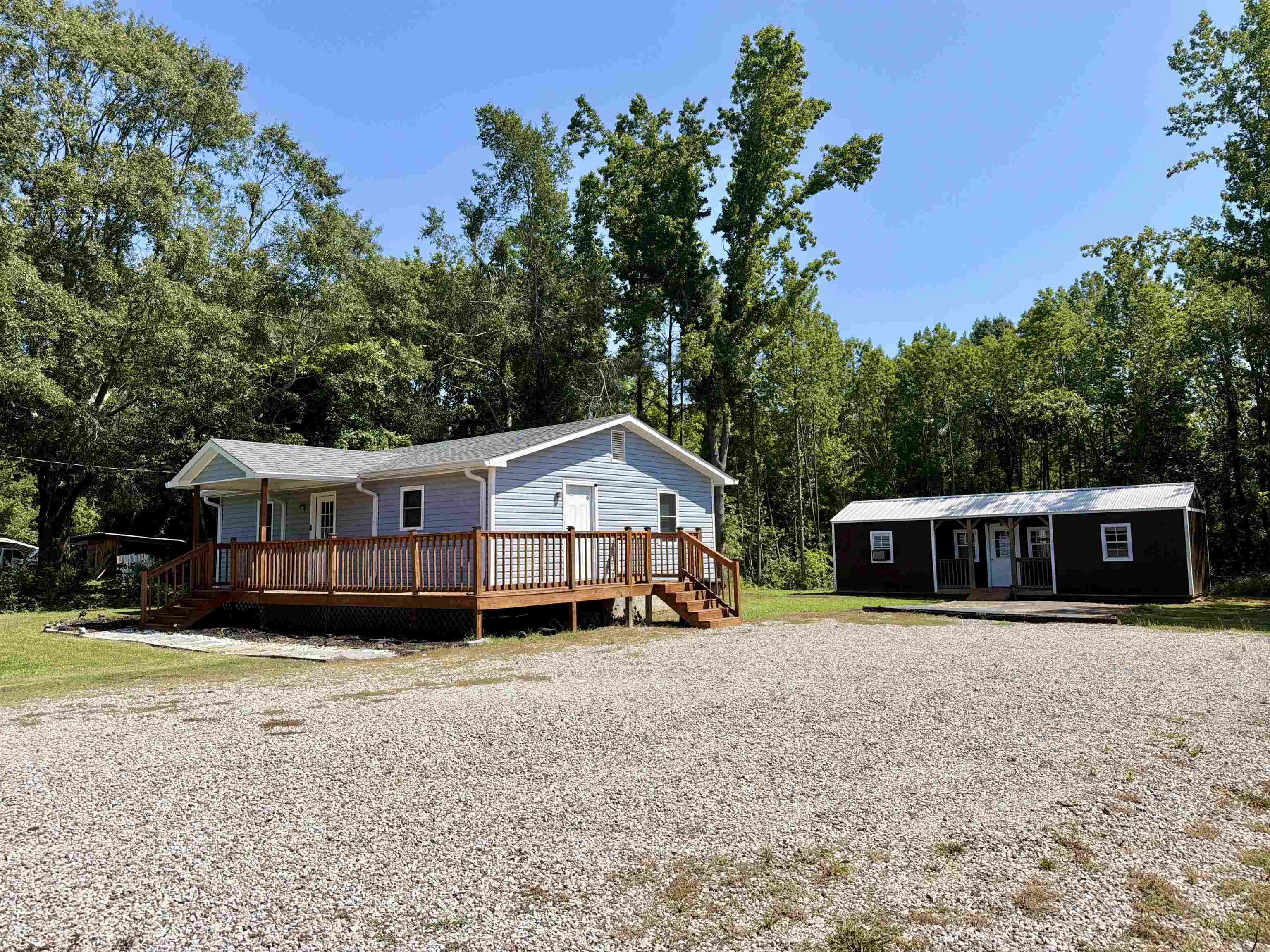 8022 45th Highway Ramer, TN 38367 - Photo 21 of 21 Light blue siding with a wood-finish deck and railings