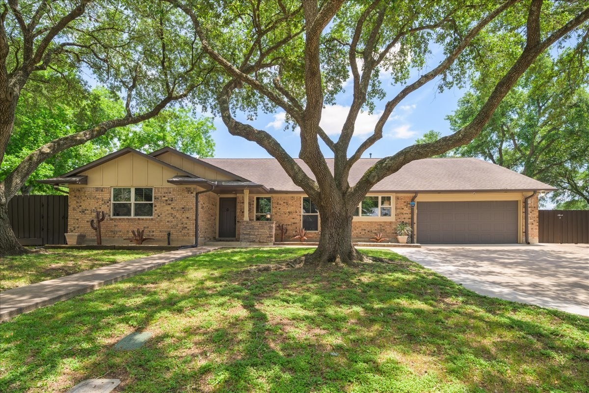 a front view of a house with a yard and trees