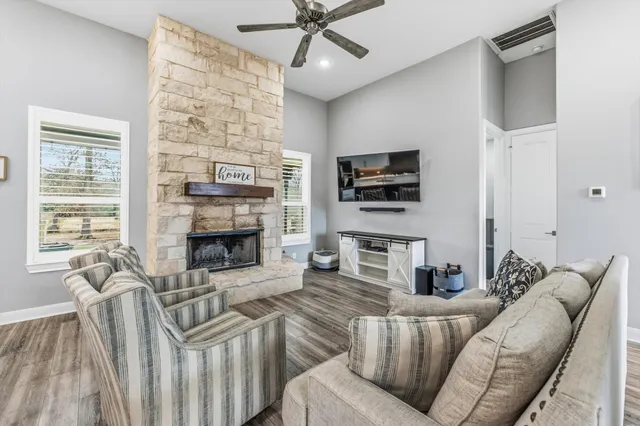 a living room with furniture a flat screen tv and a fireplace