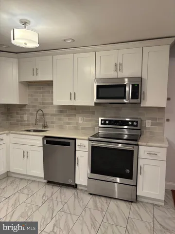 a kitchen with cabinets stainless steel appliances and a sink