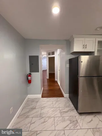 a view of a kitchen with wooden floor and a refrigerator