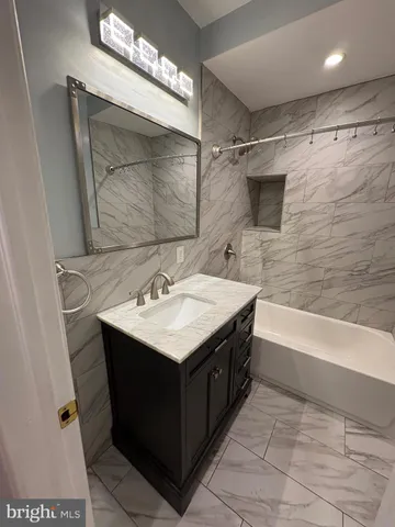 a bathroom with a sink mirror and a bathtub