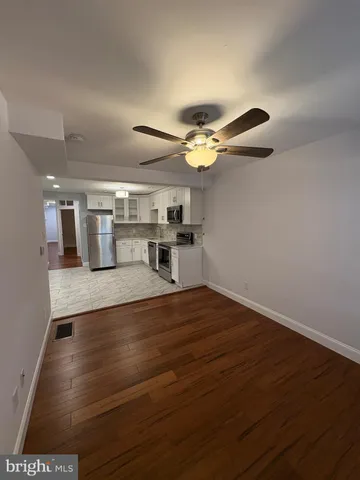 a view of a room with wooden floor and ceiling fan