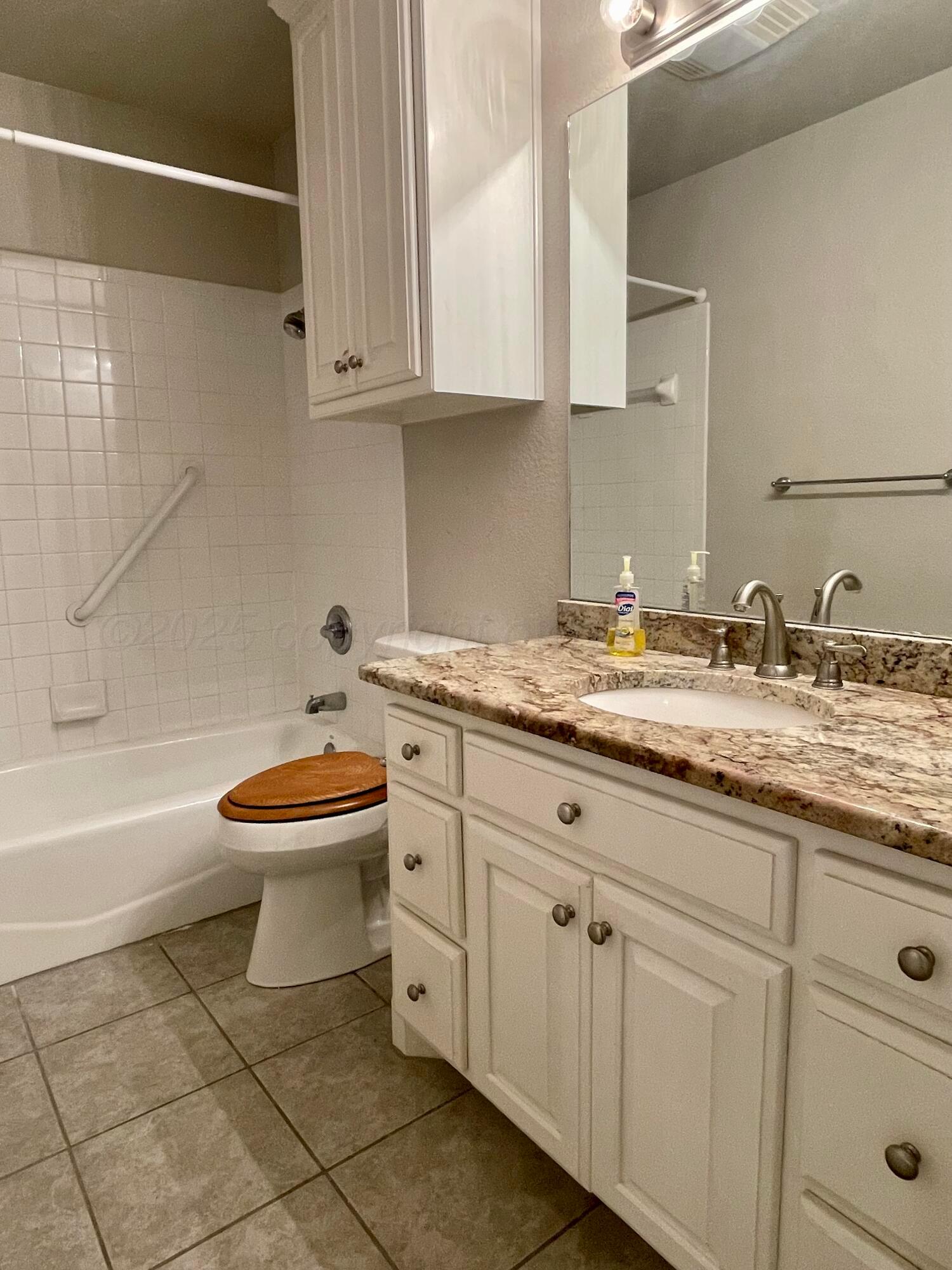 522 Carson Avenue Dumas, TX 79029 - Photo 15 of 18 a bathroom with a granite countertop toilet sink and mirror