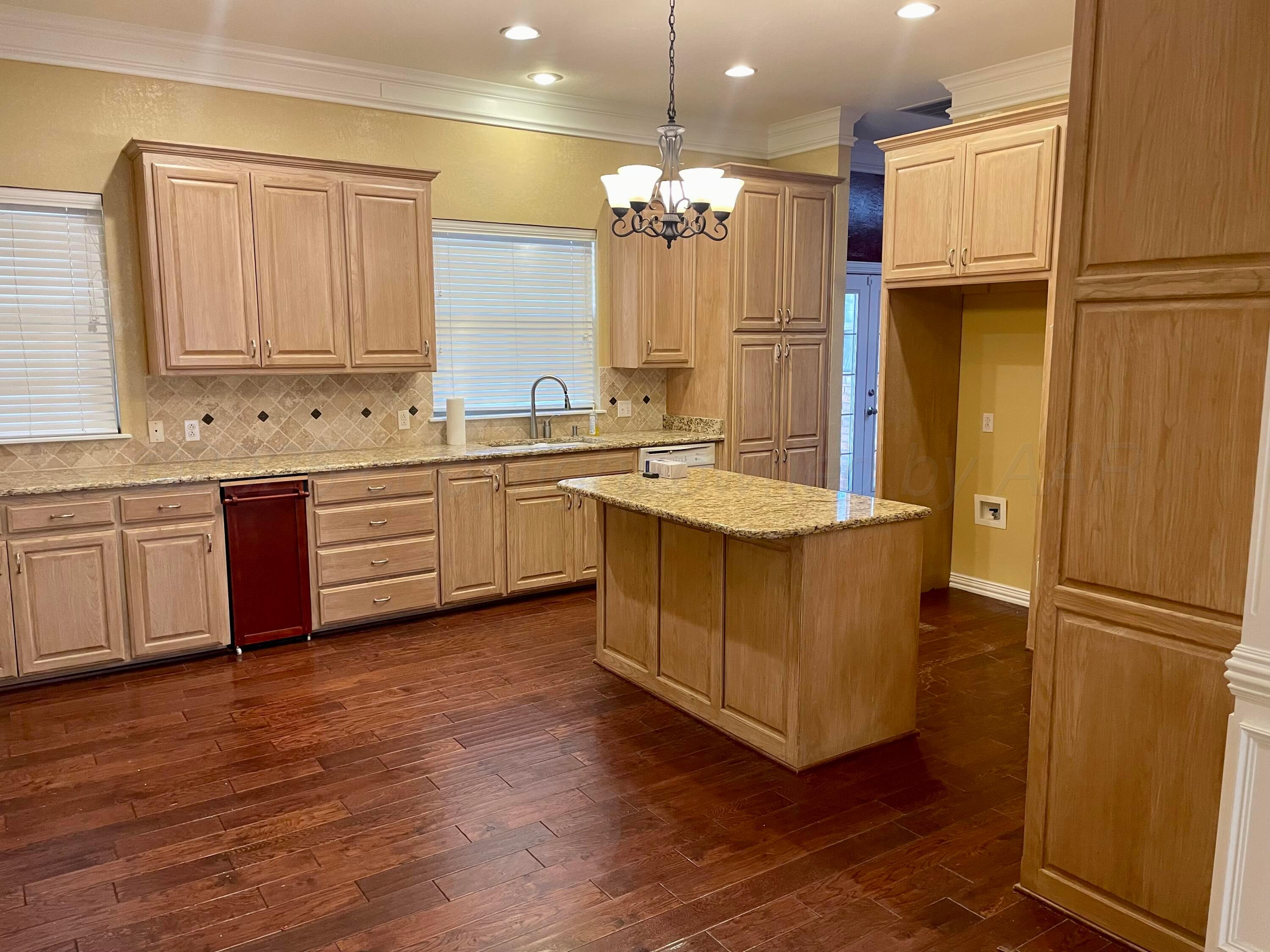 522 Carson Avenue Dumas, TX 79029 - Photo 4 of 18 a large kitchen with a refrigerator a sink and cabinets