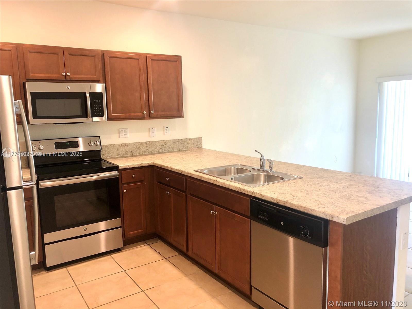 9213 West 33rd Way Hialeah, FL 33018 - Photo 3 of 13 a kitchen with stainless steel appliances granite countertop a sink stove and microwave