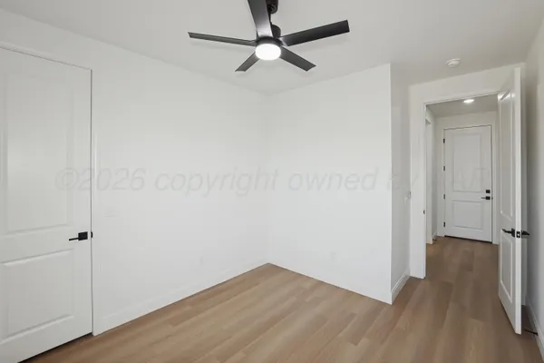 an empty room with a window and a fan