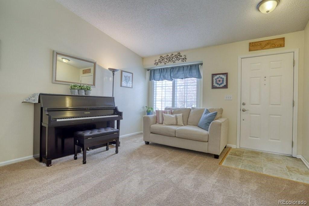 9561 South Castle Ridge Circle Highlands Ranch, CO 80129 - Photo 15 of 29 a living room with furniture a piano and a window