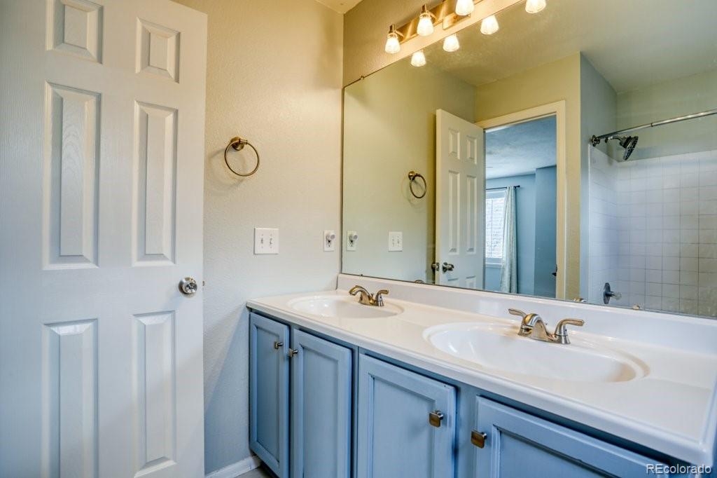 9561 South Castle Ridge Circle Highlands Ranch, CO 80129 - Photo 20 of 29 a bathroom with a double vanity sink and a mirror