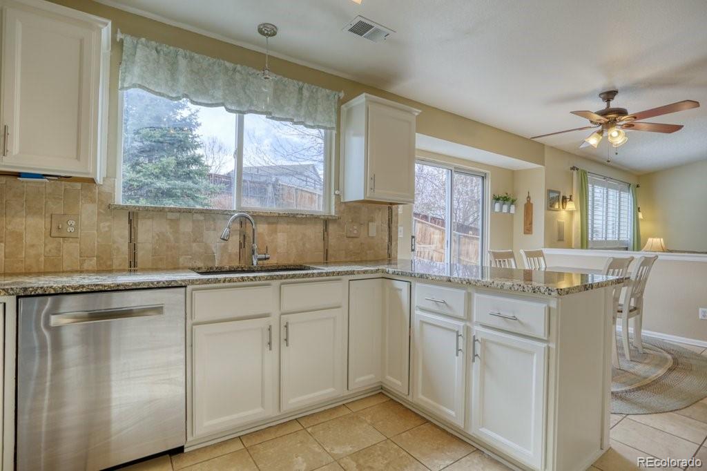 9561 South Castle Ridge Circle Highlands Ranch, CO 80129 - Photo 9 of 29 a kitchen with white cabinets and window