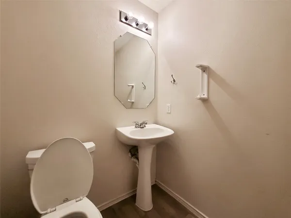 a bathroom with a sink mirror and toilet