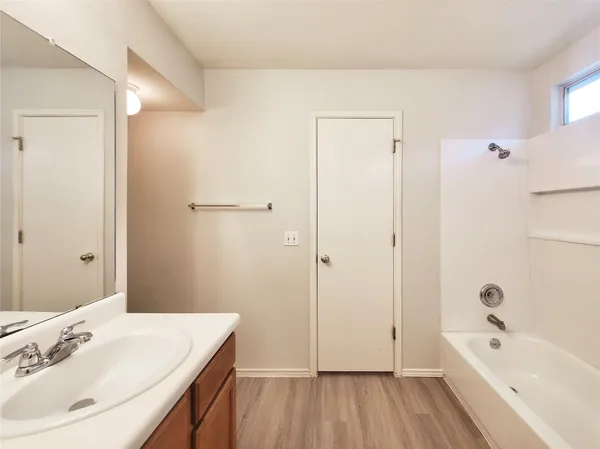 a bathroom with a bathtub a sink a vanity and a large mirror