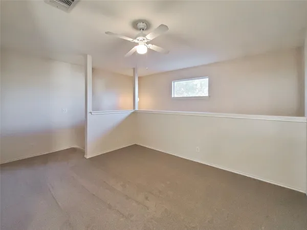 an empty room with a window and a fan