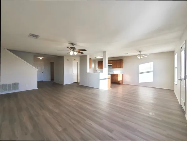 a view of empty room with wooden floor and window