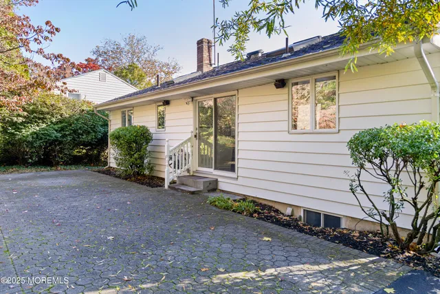 a view of a house with a yard and potted plants