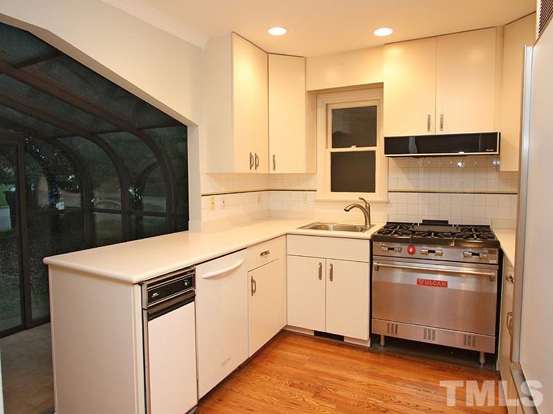 2109 Camrose Street Raleigh, NC 27608 - Photo 3 of 12 a kitchen with stainless steel appliances white cabinets and wooden floor