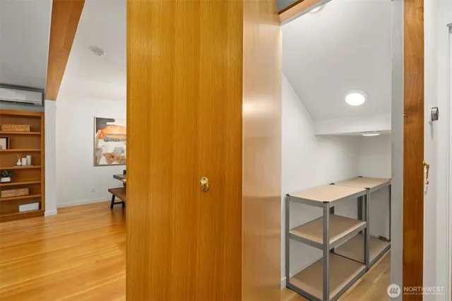 a view of a hallway with wooden floor and furniture