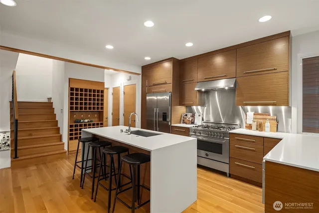 a kitchen with stainless steel appliances kitchen island granite countertop a stove and a refrigerator