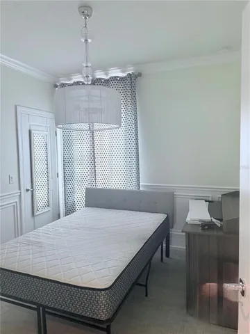 a bedroom with a bed and a chandelier
