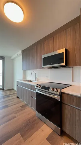 a kitchen with stainless steel appliances a stove microwave and sink