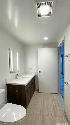 a bathroom with a sink vanity granite and a toilet