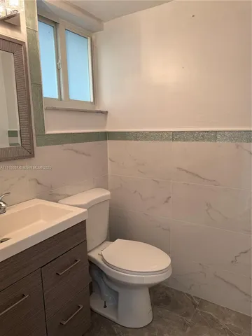 a bathroom with a toilet a sink and mirror