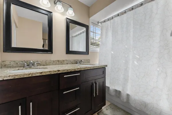 a bathroom with a granite countertop sink and a mirror