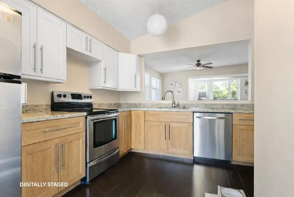 a kitchen with granite countertop white cabinets and white appliances