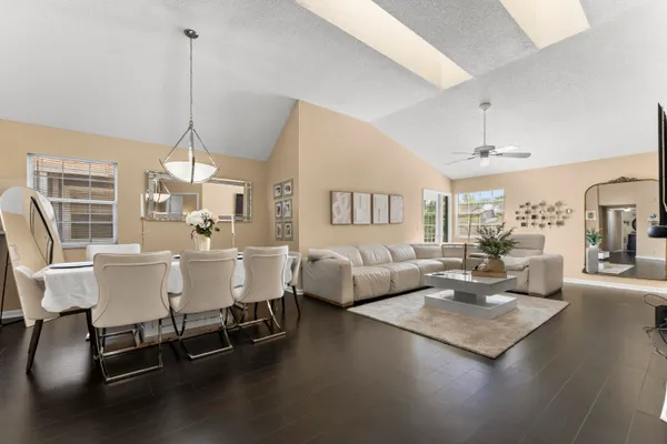a living room with couches a coffee table and chairs with wooden floor
