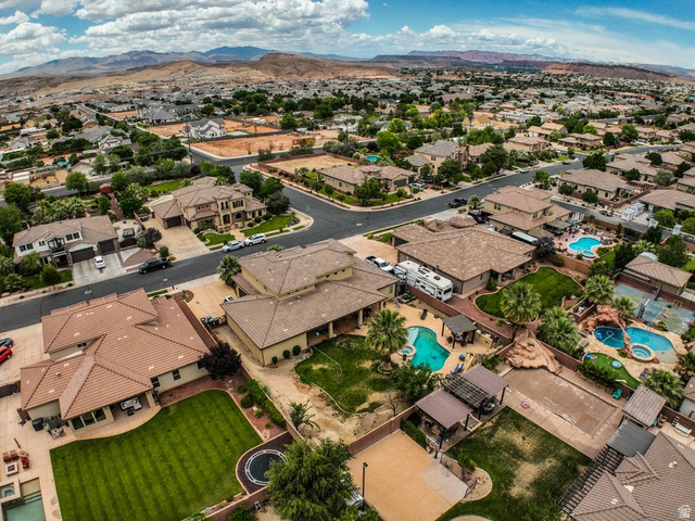 3683 South 2640 West St. George, UT 84790 - Photo 26 of 41 Expansive aerial view of a residential neighborhood featuring multiple properties with private swimming pools, covered patios, and mature landscaping
