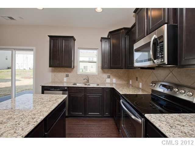 2211 Durand Road, Unit 77 Fort Mill, SC 29715 - Photo 7 of 16 a kitchen with stainless steel appliances granite countertop a sink stove and cabinets