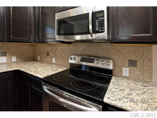 2211 Durand Road, Unit 77 Fort Mill, SC 29715 - Photo 8 of 16 a kitchen with stainless steel appliances granite countertop a stove and a microwave