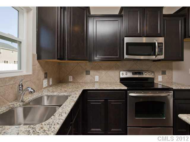 2211 Durand Road, Unit 77 Fort Mill, SC 29715 - Photo 9 of 16 a kitchen with granite countertop a sink and a stove