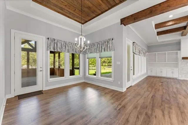 a view of a kitchen with wooden floor and cabinets