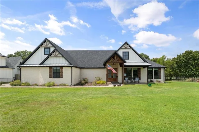 a front view of a house with a yard and trees