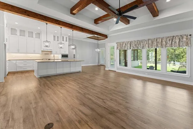 a large kitchen with kitchen island a large counter space wooden floor and stainless steel appliances
