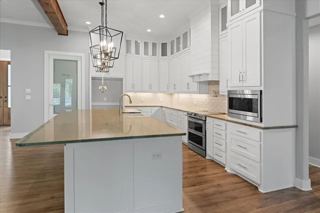 a kitchen with granite countertop white cabinets and white appliances