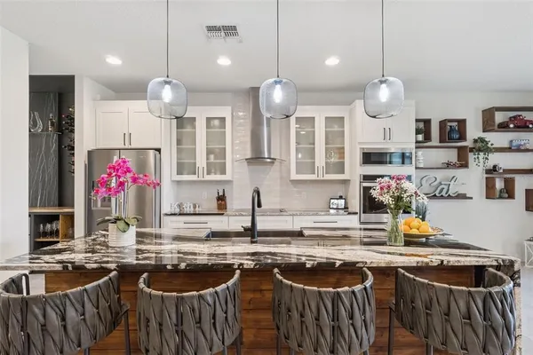 a kitchen with stainless steel appliances granite countertop a stove a sink and a refrigerator