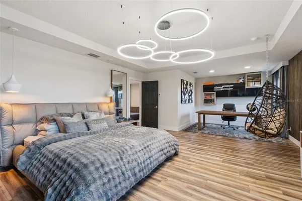 a spacious bedroom with a bed a table and chair
