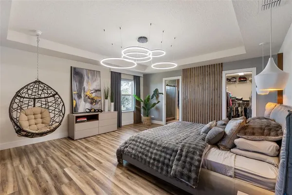 a bedroom with a large bed and a chandelier