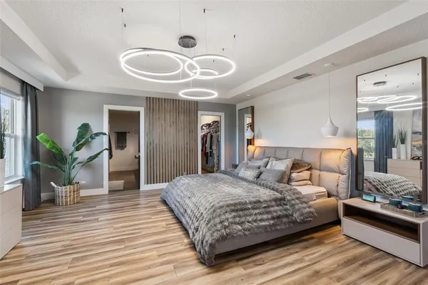 a bedroom with a large bed and a chandelier