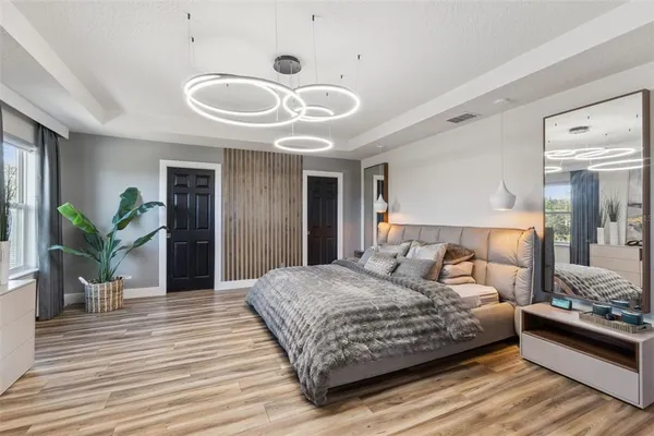 a bedroom with a large bed and a chandelier