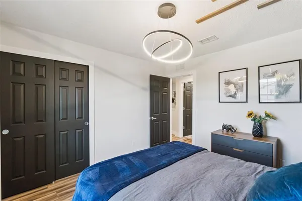 a bedroom with a bed and a chandelier