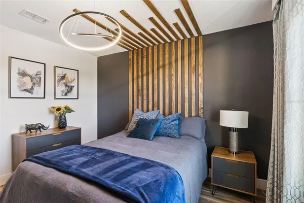 a bedroom with a bed and dresser with mirror