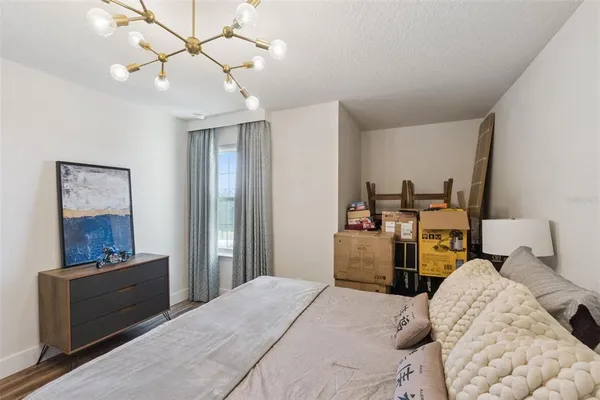 a bedroom with a bed and a chandelier