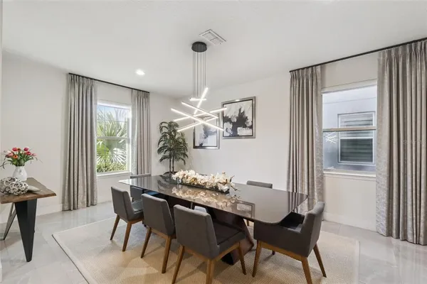 a dining room with furniture a rug and a chandelier