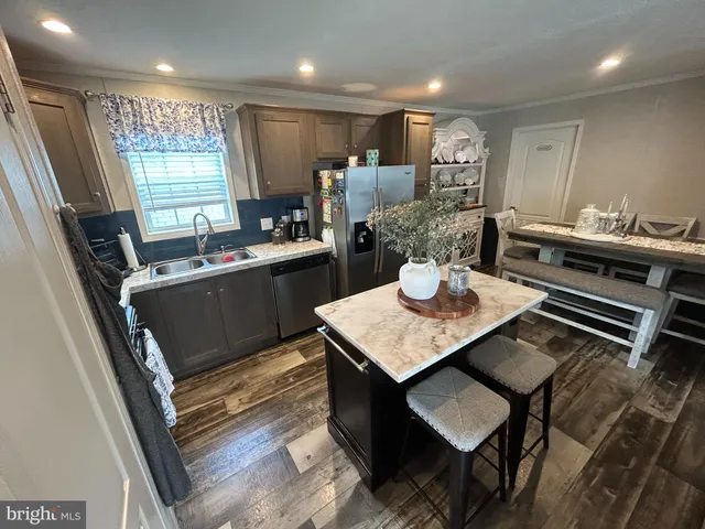 a kitchen with kitchen island a stove a table and chairs in it